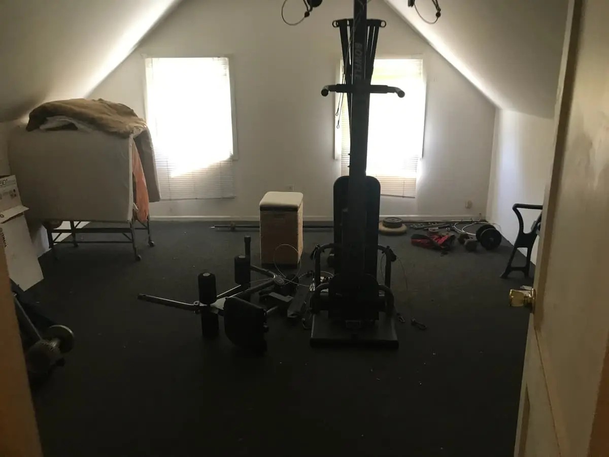 Behind on mortgage payments in Levittown: attic room with exercise equipment and boxes