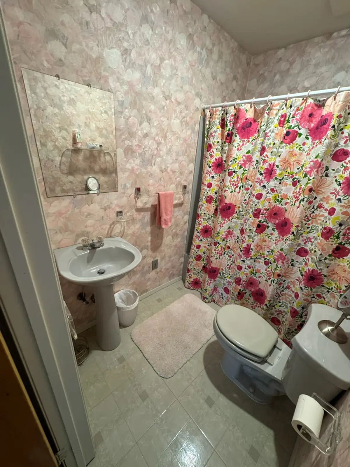 Selling a house in probate in Levittown: bathroom with pink floral tile and a shower curtain