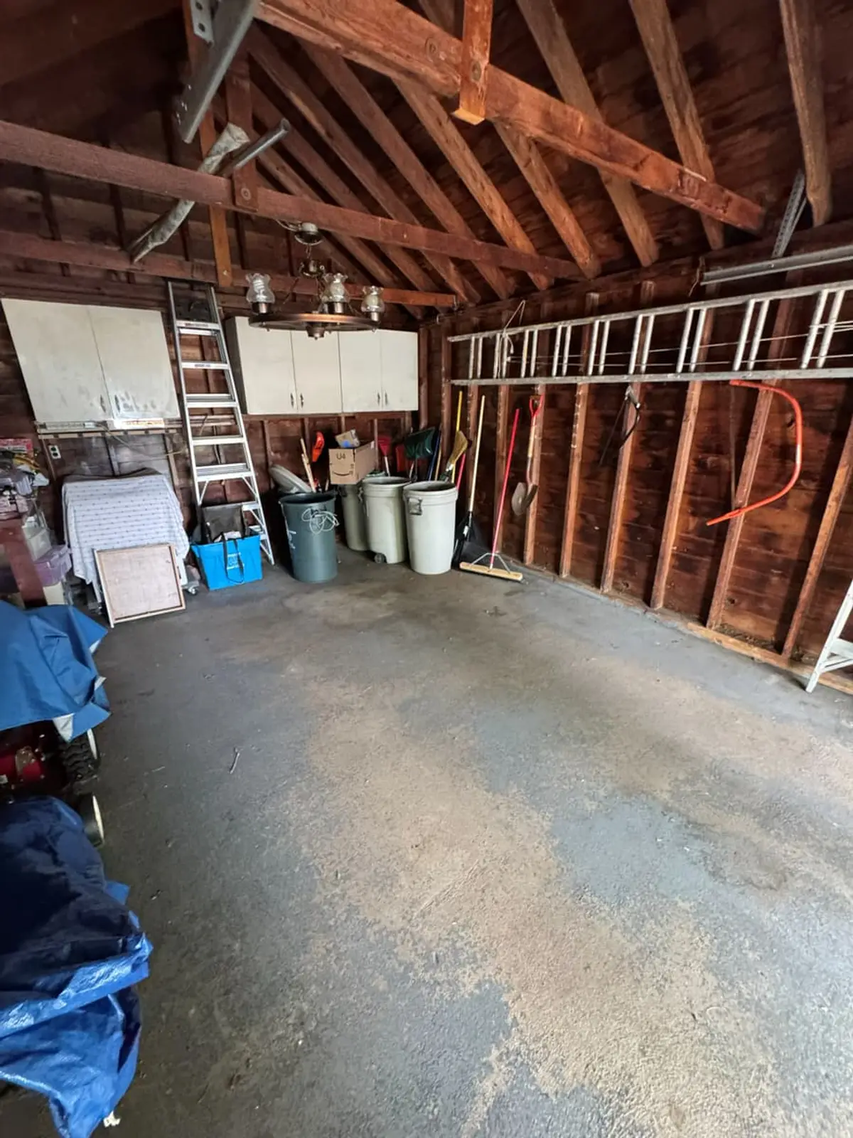 Selling a house during a divorce in Levittown: garage with ladders and stored equipment along open studs