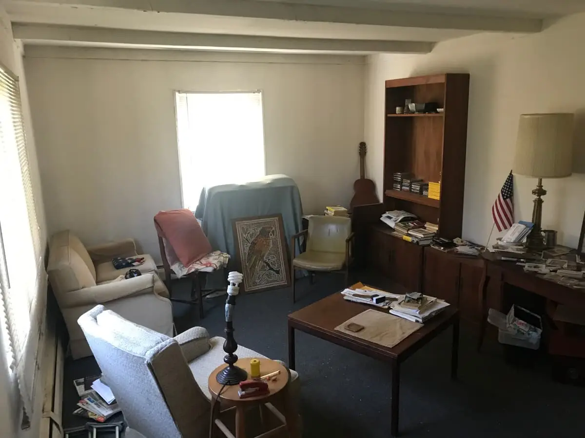 Selling with a non-paying tenant in Levittown: living room with old armchairs and a coffee table